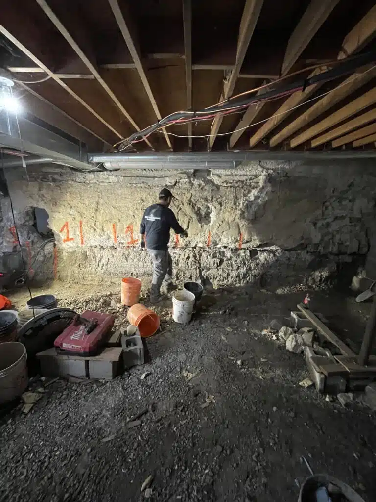 Contractor carefully cutting foundation wall for precise basement egress window opening
