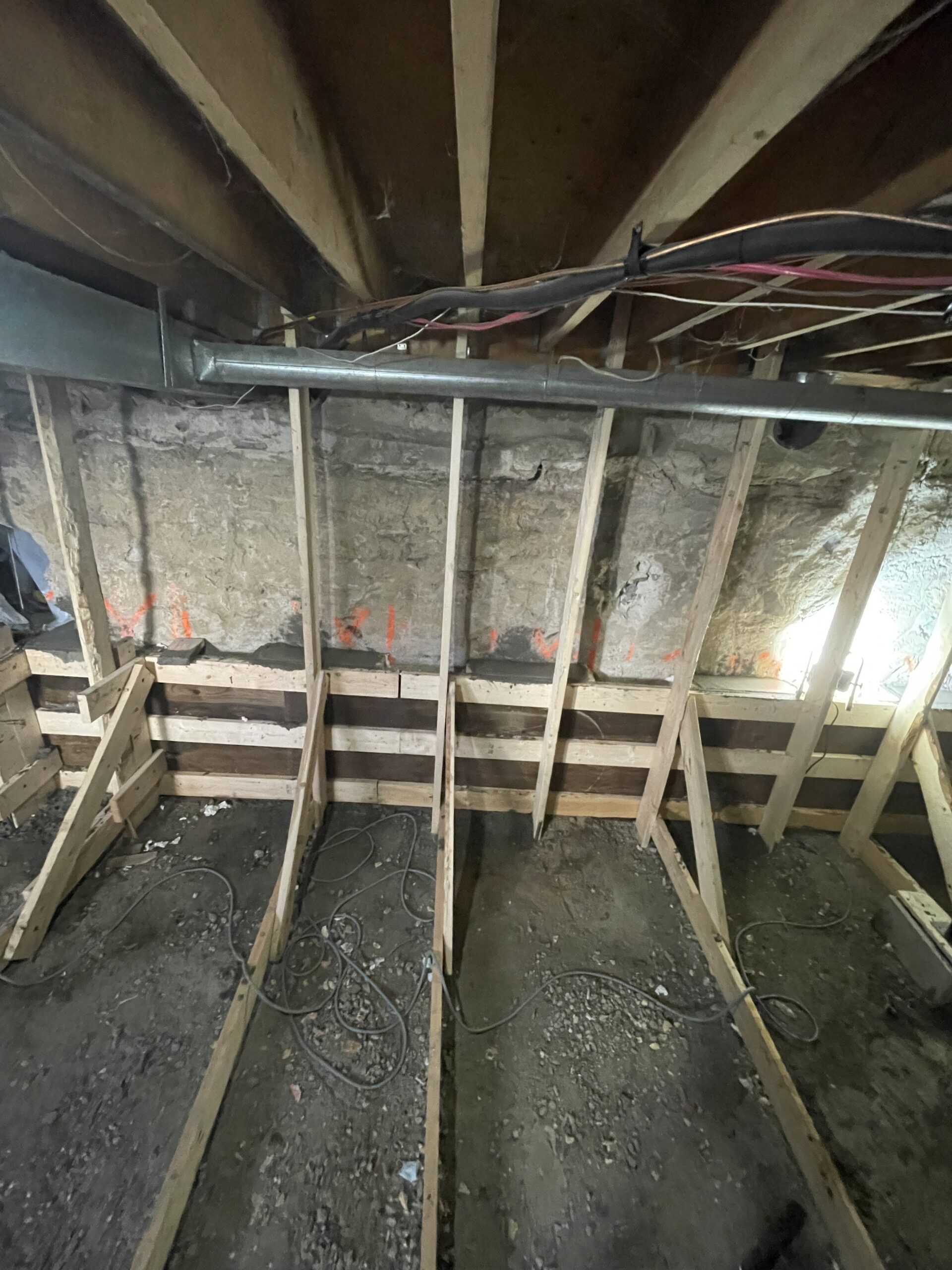 Installer checking window well depth and foundation cut for accurate egress fit, Installer measuring foundation opening for precise egress window fit and drainage