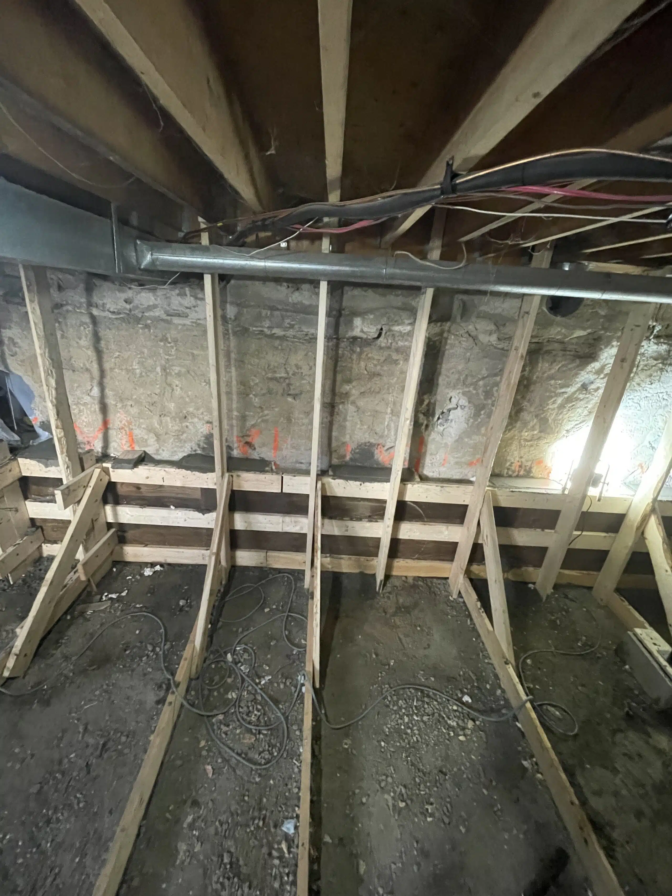 Installer checking window well depth and foundation cut for accurate egress fit, Installer measuring foundation opening for precise egress window fit and drainage