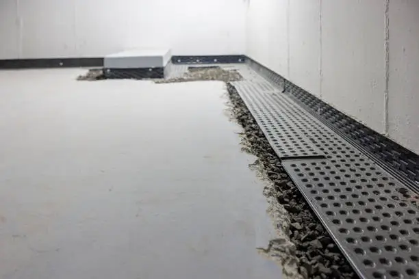 Basement Waterproofing in Matawatchan - ON as a crew seals foundation cracks beside a home, Specialist assessing basement waterproofing needs in a Maynooth - ON home with visible wall moisture